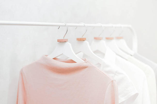 Set of row female clothing on white hangers. Pastel wardrobe. - Φωτογραφία, εικόνα