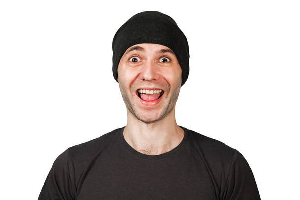 Young funny smiling man with wide eyes in hat isolated on white background - Foto, immagini