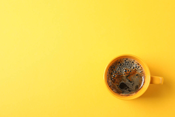 Tasse Kaffee mit schaumigem Schaum auf farbigem Hintergrund, Platz für - Foto, Bild
