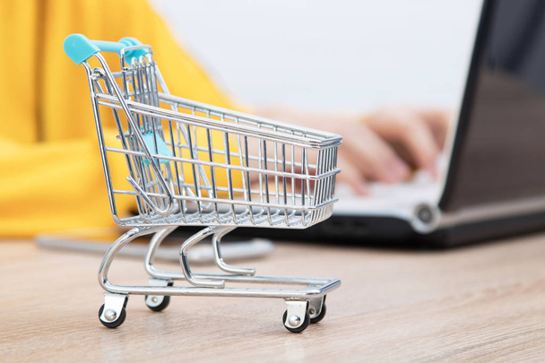 hands typing on the computer and shopping cart, online purchases - Φωτογραφία, εικόνα