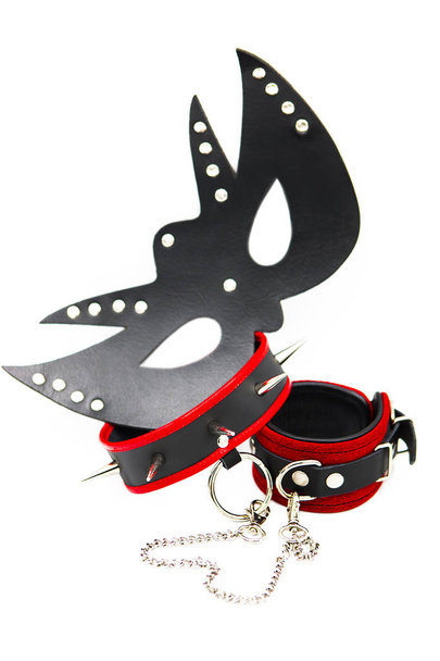 Кожаная маска, наручники и воротник с шипами, соединенными цепью, изолированной на белом фоне. Секс игрушки для bdsm. Сексуальное рабство
. - Фото, изображение