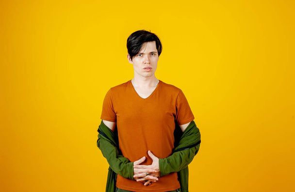 Young stylish man posing on bright yellow background  - Foto, afbeelding
