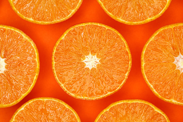 Mandarinas, fatias de tangerina fresca em um fundo laranja, conceito minimalista, monocromático. Padrão de frutas, flat lay
 - Foto, Imagem