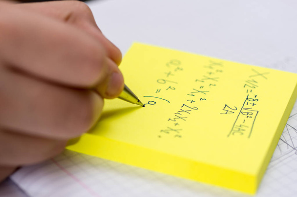 Pisanie na żółtym przyklejone notatki z bliska. Ołówek w ręce dzieci. - Zdjęcie, obraz