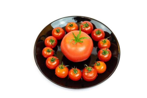 Tomatoes in a black plate isolated on white background. Composition of red tomatoes on a white background. Place for text - Photo, Image
