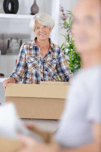 mature couple with moving boxes at new home - Foto, Imagem