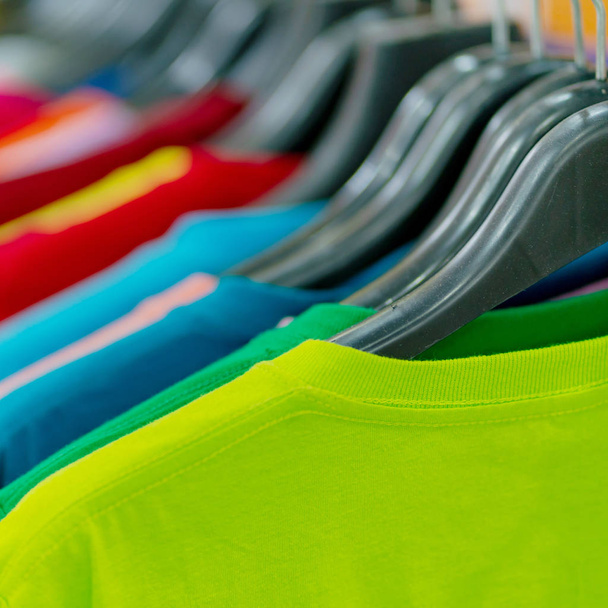 Primer plano de camisetas coloridas en perchas
 - Foto, Imagen