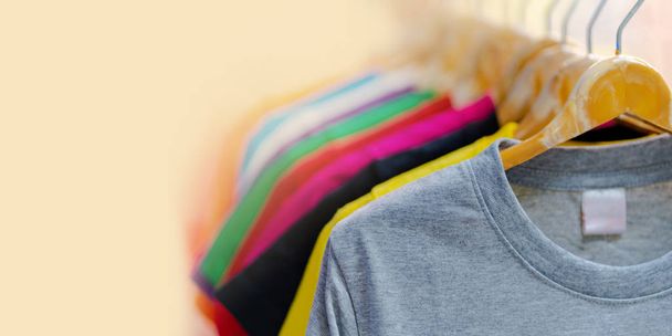 Крупный план красочных футболок на вешалках
 - Фото, изображение