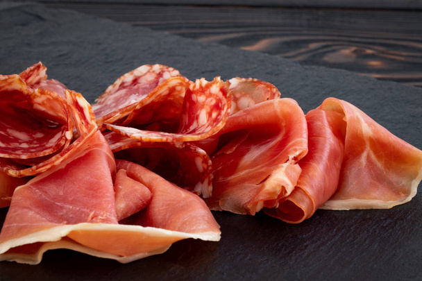 Italiaanse prosciutto crudo of Spaanse Jamon en worstjes. Rauwe ham  - Foto, afbeelding