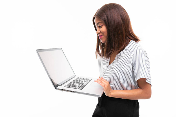 smilling dark-skinned young girl present smth on the laptop isolated on background - Foto, afbeelding