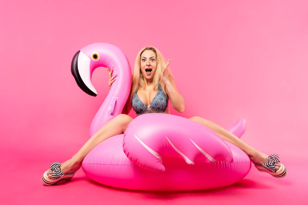 Photo of woman in swimming suit on inflatable flamingo water toy - Fotó, kép