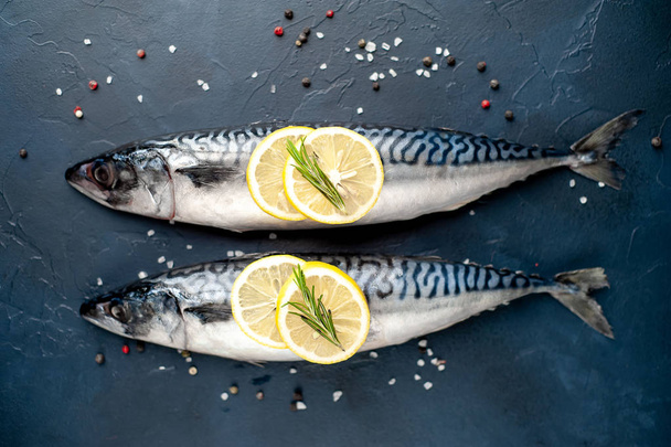 Syrové ryby s citronovou výsečí a rozmarnými větvičky na černém kamenném pozadí - Fotografie, Obrázek