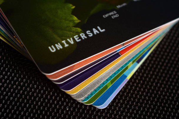 Cartões de crédito são exibidos por um ventilador em um fundo preto
. - Foto, Imagem