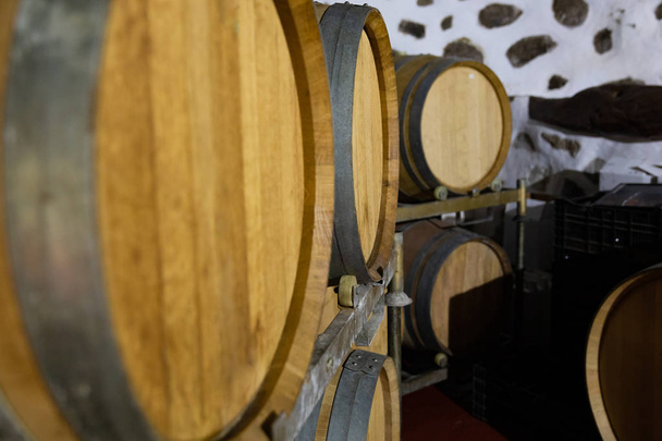 Gros plan des tonneaux en bois en chêne stockés à la cave à vin
 - Photo, image