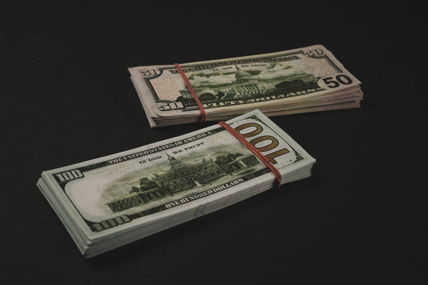Banknoty dolara amerykańskiego izolowane na czarnym tle. - Zdjęcie, obraz