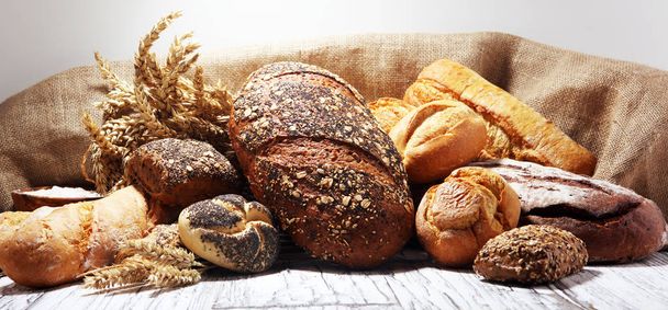 Ποικιλία από ψημένο ψωμί και ψωμάκια σε ρουστίκ λευκό φούρνο - Φωτογραφία, εικόνα