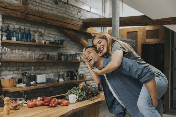 Schönes junges Paar, das zusammen in der rustikalen Küche Spaß hat - Foto, Bild