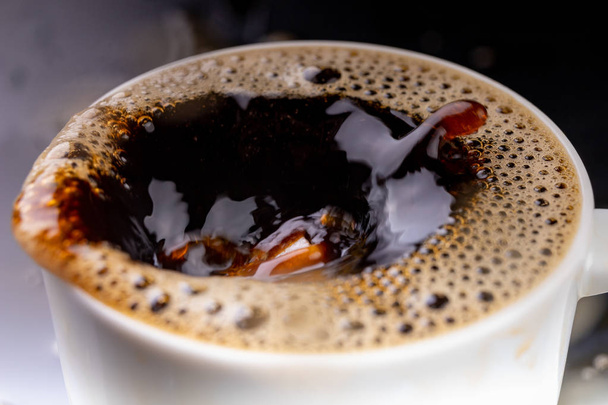 Пролил чёрный кофе в чашку на чёрный стол. Плохая поверхность t
 - Фото, изображение