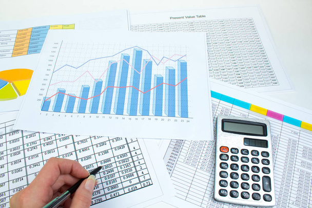 Финансовые напечатанные бумажные графики, графики и диаграммы на столе. Вид сверху
 - Фото, изображение