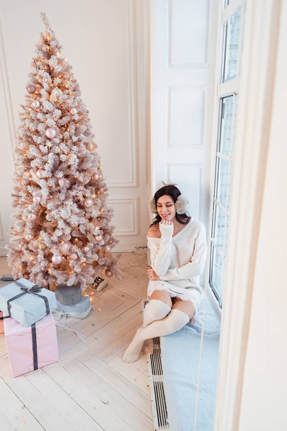 Mujer joven en un vestido elegante cerca del árbol de Navidad - Foto, Imagen
