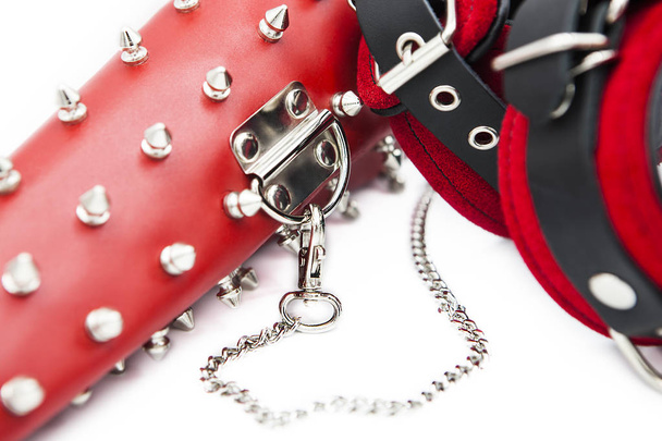 Sex toys for bdsm. Leather handcuffs and clamps for hands with thorns. Isolated handcuffs with chain on white background - Photo, Image