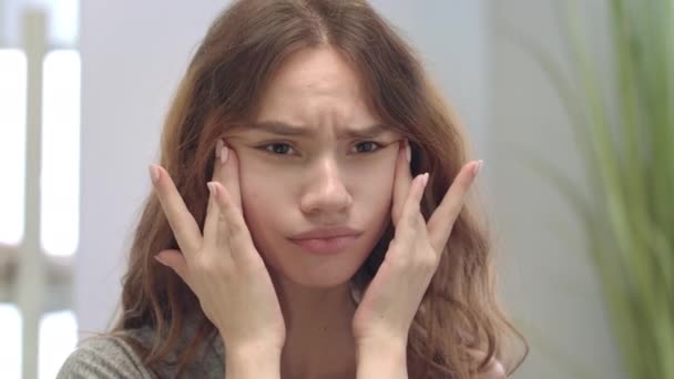 Αναστατωμένη έφηβος κορίτσι αναζητούν πρόβλημα του δέρματος και αγγίζοντας το πρόσωπο μπροστά καθρέφτη του μπάνιου - Πλάνα, βίντεο