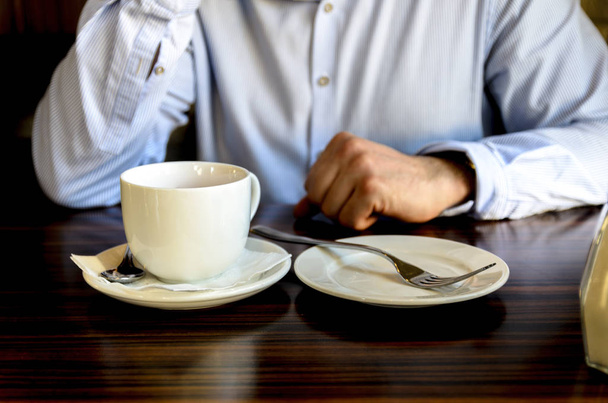 mladého muže po příjemné čajové party, která odpočívá a telefonovala v kavárně. pracovní oběd, firemní setkání - Fotografie, Obrázek