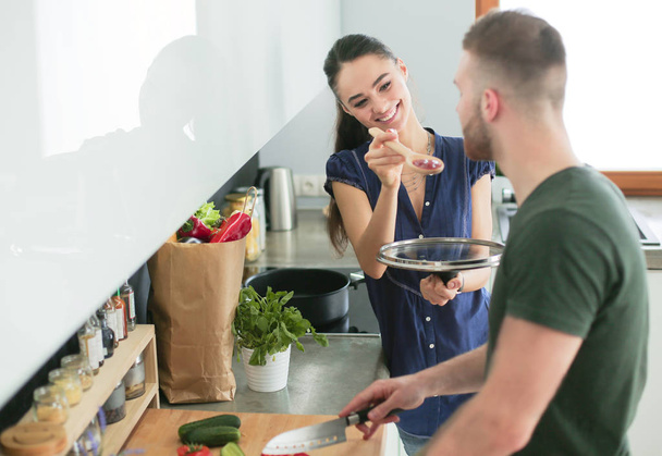 Couple cooking together in their kitchen at home - Foto, Bild