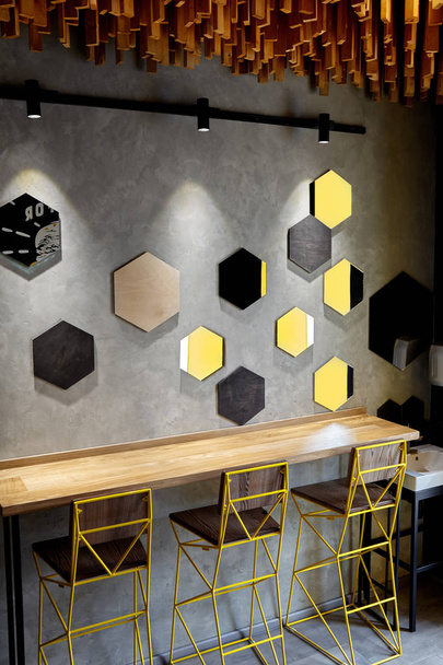 カフェのインテリア.ロフトスペースデザイン、木製テーブル、コンクリート壁。創造的なミニマルなカフェのインテリア、シンプルさと幾何学の概念、黒と黄色の色。クリエイティブスペース - 写真・画像
