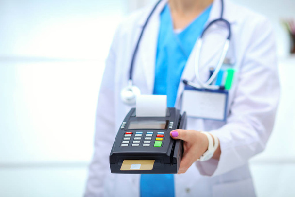 Doctor is holding payment terminal in hands. Paying for health care. Doctor - Φωτογραφία, εικόνα