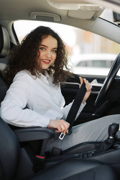 Retrato de cerca de la joven mujer abrocharse el cinturón de seguridad en su coche
 - Foto, Imagen