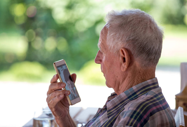 携帯電話で話している老人 - 写真・画像