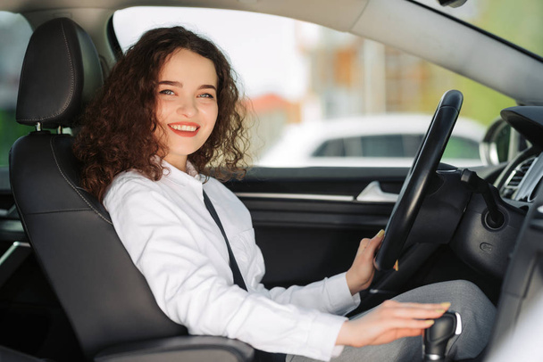 Beautiful young happy smiling business woman driving her new car. - Zdjęcie, obraz