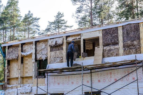 o isolamento de uma casa de armação de lã mineral, paredes de madeira compensada com fechaduras
. - Foto, Imagem