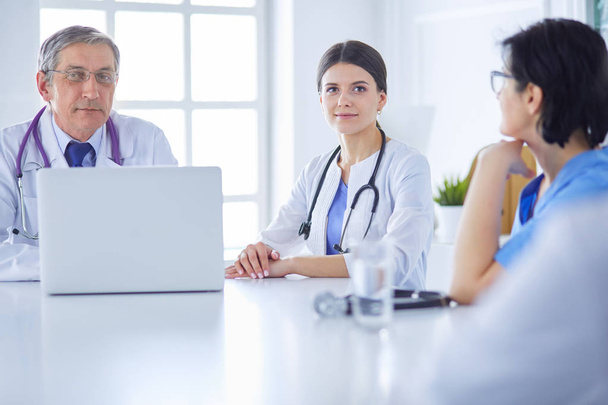 Seriöses Ärzteteam mit Laptop in einem hellen Beratungsraum - Foto, Bild