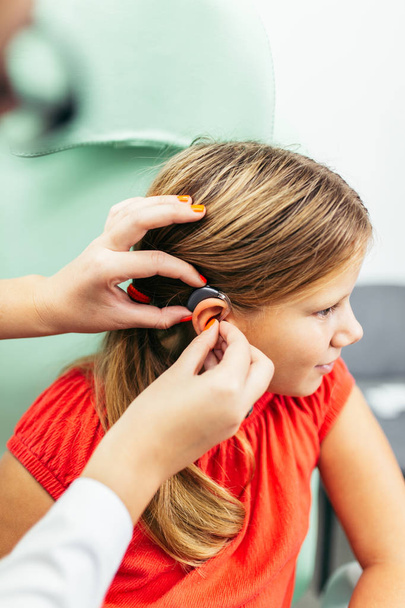 Young girl at medical examination or hearing aid checkup in otolaryngologist's office - Foto, imagen