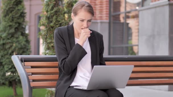 Jeune femme d'affaires tousse tout en travaillant sur ordinateur portable en plein air
 - Séquence, vidéo
