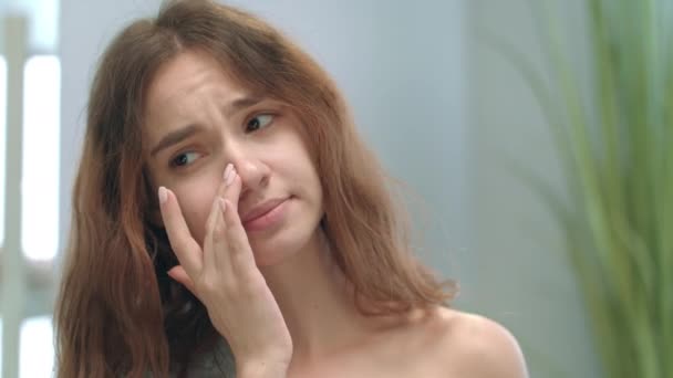 Chica poco saludable con la nariz tapada usando aerosol nasal para el tratamiento en frío - Imágenes, Vídeo