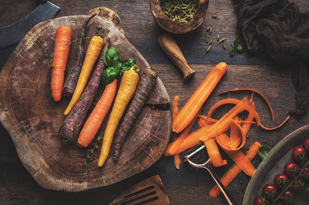 fresh organic rainbow carrots and tomatoes on wooden table - Фото, зображення