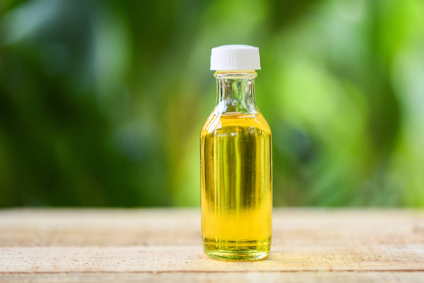 Sesame oil in glass bottles on wooden and nature green  - Photo, Image