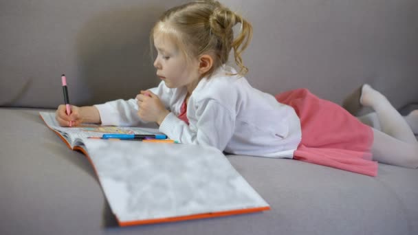 Cute little girl drawing with markers in coloring book, art therapy and hobby - Video