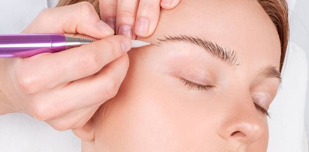 Microblading eyebrows. Attractive woman getting facial care and permanent makeup.  - Foto, Imagen