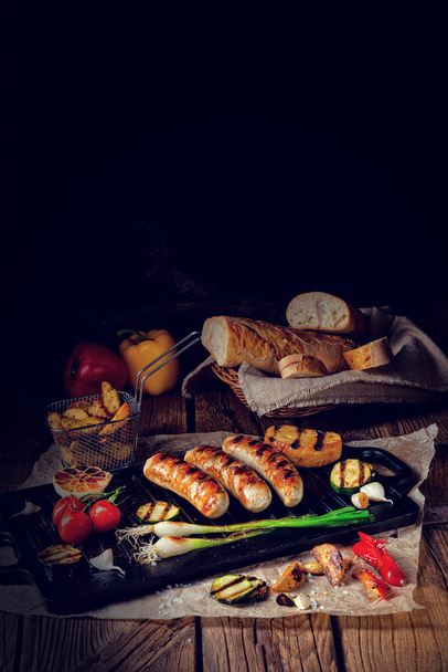 Delicious  grilled sausage with various grilled vegetables - Fotó, kép