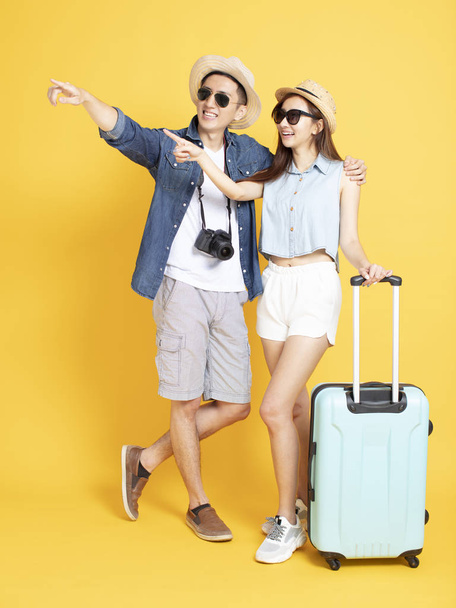 Полная длина азиатской пары с сумкой для путешествий и камерой наблюдения
 - Фото, изображение