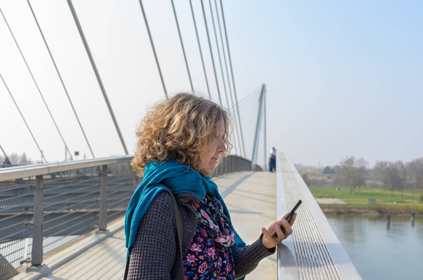 Donna sul ponte pedonale con cellulare
 - Foto, immagini