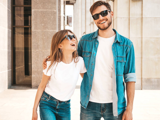 Portrait of smiling beautiful girl and her handsome boyfriend. Woman in casual summer jeans clothes. Happy cheerful family. Female having fun on the street background in sunglasses - Foto, Bild