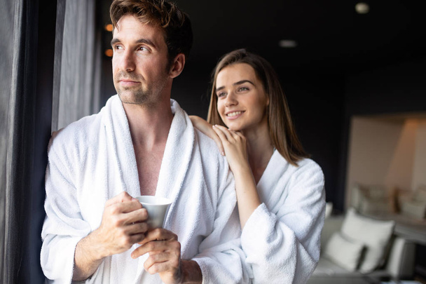 Couple in bathrobes enjoying wellness weekend in modern hotel - Foto, Imagen