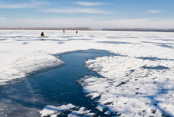 Talvimaisema - yksinäiset kalastajat jäätyneellä joella
. - Valokuva, kuva