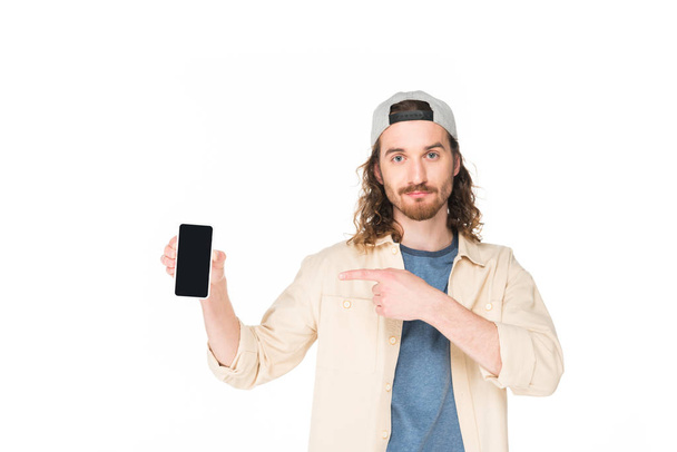 junger Mann hält Smartphone in der Hand und zeigt mit dem Finger darauf - Foto, Bild