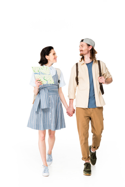 full length view of girl holding map and young man holding hands and smiling isolated on white - Foto, Imagem